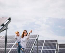 Mulher com criança no colo satisfeita ao contratar uma empresa de energia solar