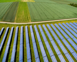 diversas placas de energia solar espalhadas em uma grande propriedade rural do setor do agronegócio