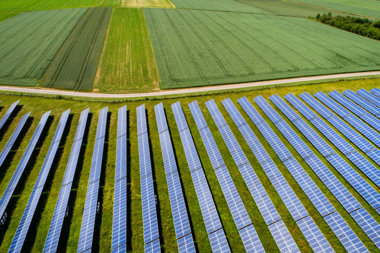 diversas placas de energia solar espalhadas em uma grande propriedade rural do setor do agronegócio