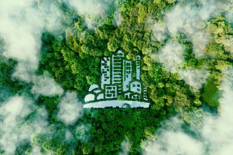 Imagem aérea de uma floresta com nuvens e formatos simbólicos de prédios na floresta, formando uma cidade sustentável.